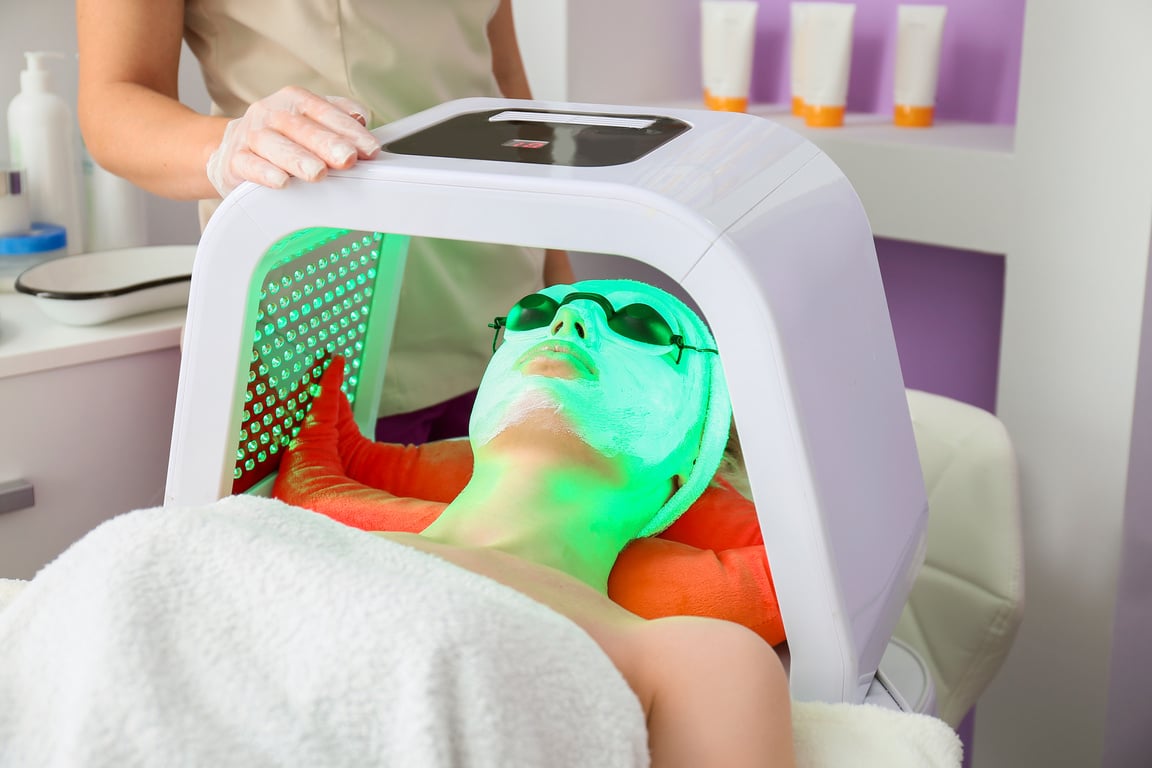 Woman Undergoing Procedure of Facial Chromotherapy in Beauty Salon